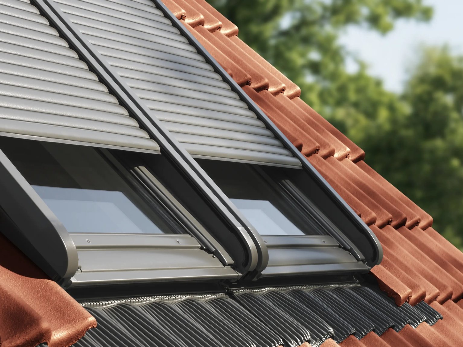 Closed VELUX roof windows on a red tiled roof with solar roller shutter.
