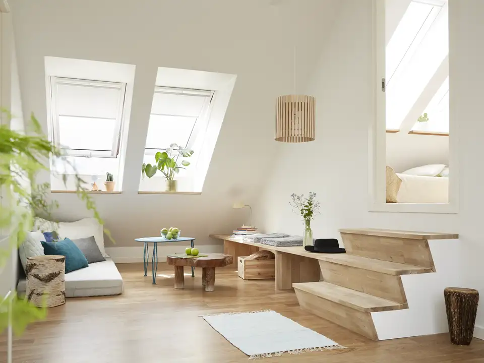 Mansarda luminosa con stanze su più livelli unite da gradini interni, finestre per tetti VELUX affiancate.