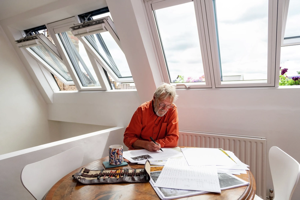 Man working from home under his 3in1 VELUX roof windows