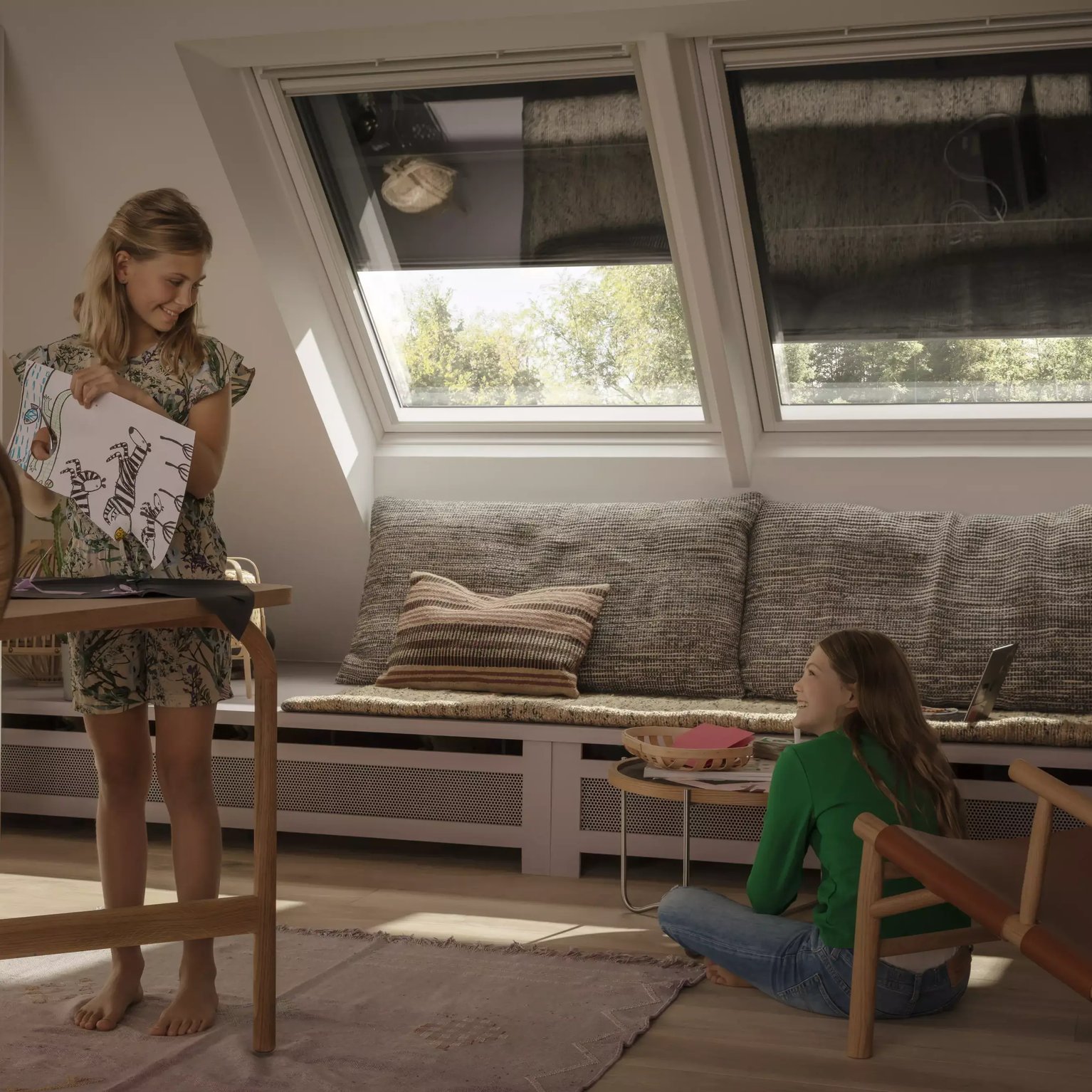 Attic playroom with sloped ceiling, VELUX roof windows, and children playing.