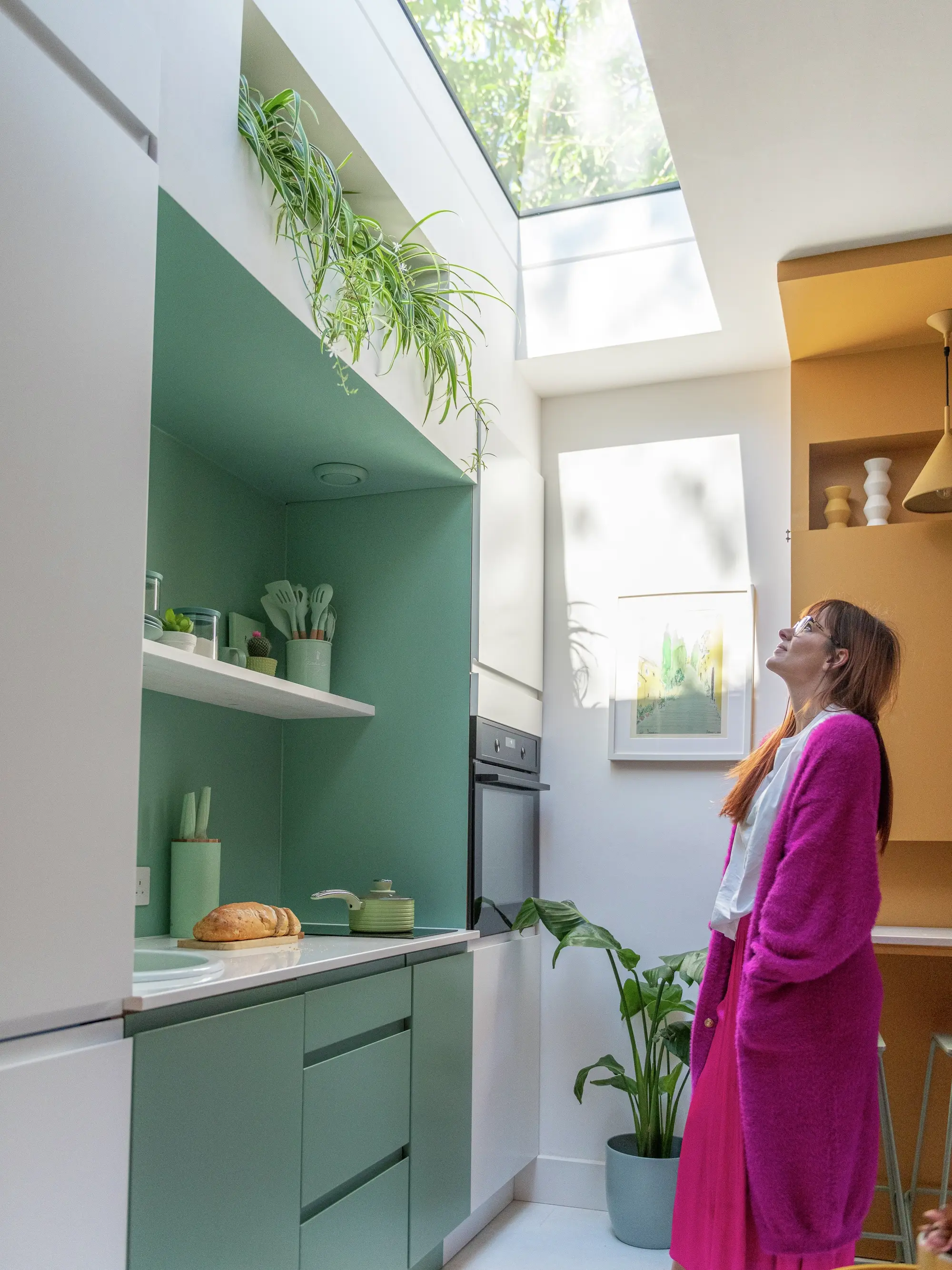 Bright modern kitchen with green cupboards and a VELUX skylight.