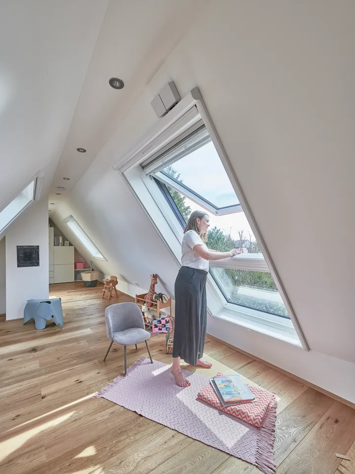 Geräumiger Dachboden-Spielraum mit VELUX Dachflächenfenster und hölzernem Boden, erfüllt mit natürlichem Licht.