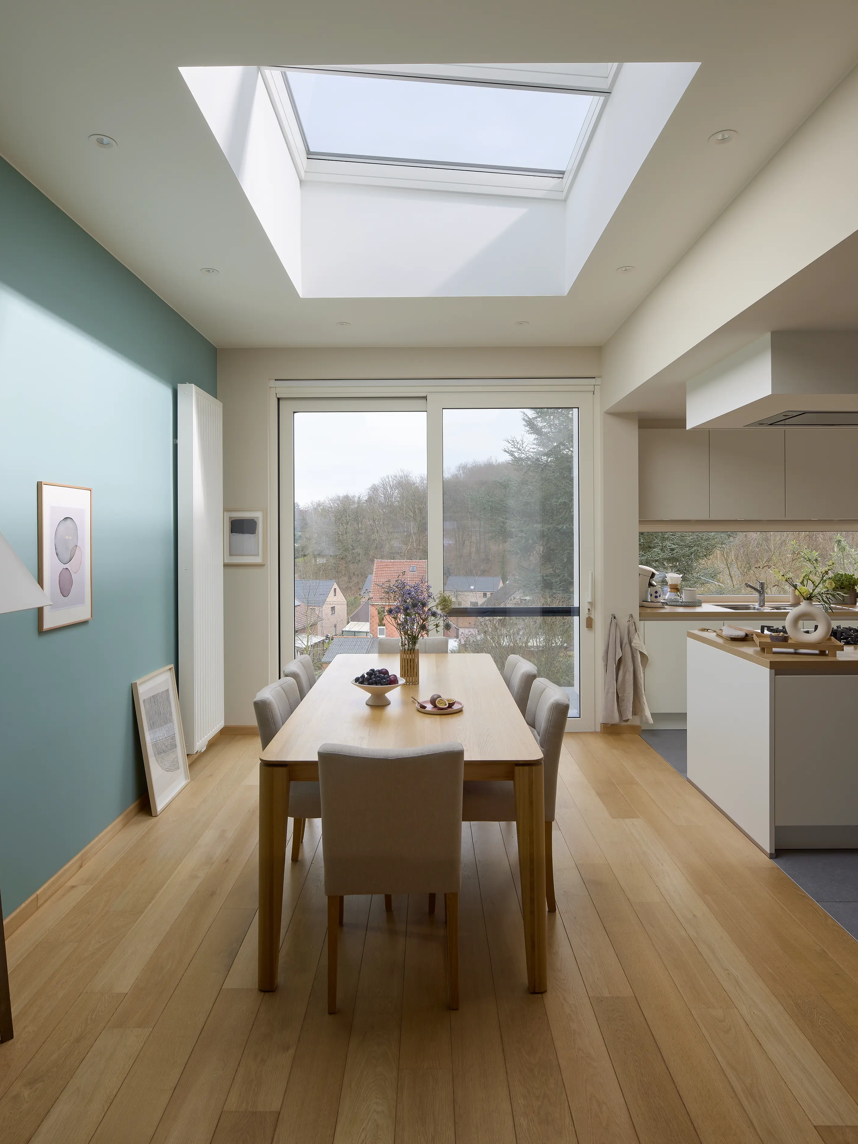 Dining room with VELUX roof window and modern kitchen area.