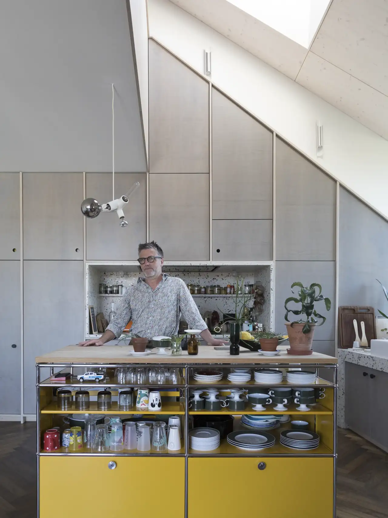 Mann steht an einer Kochinsel in Küche mit Dachschräge | VELUX Magazin
