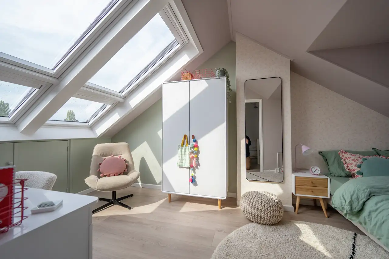 Attic living room with sloped ceiling and VELUX roof windows, modern decor.
