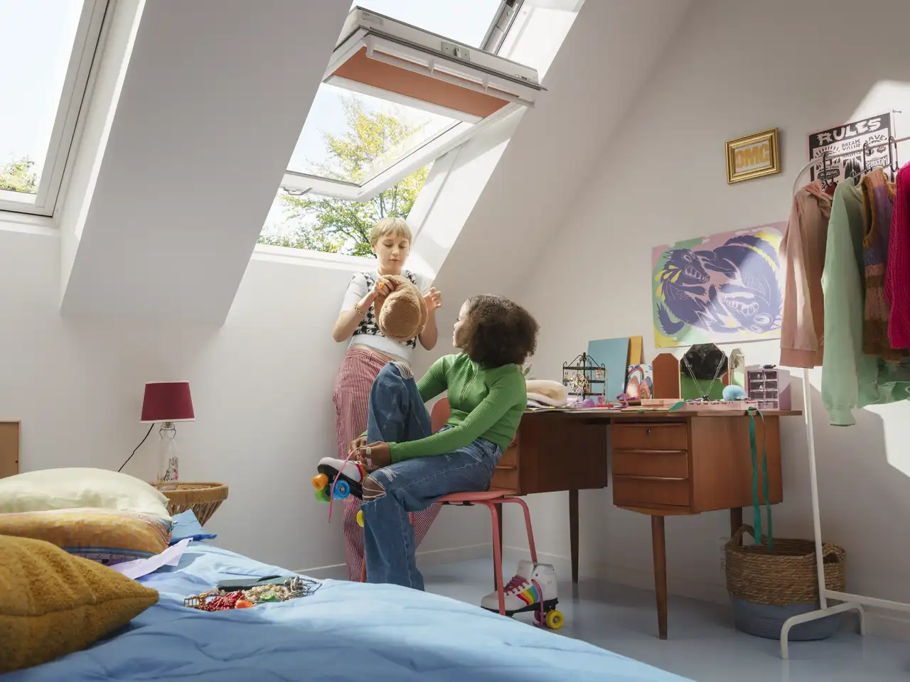 Deux jeunes discutent dans leur chambre d'adolescent avec de grandes fenêtres de toit  | Magazine VELUX