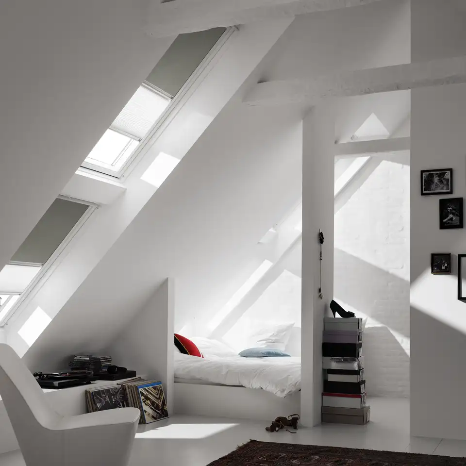 chambre sous les combles avec fenêtres de toit VELUX superposées et stores jour et nuit VELUX