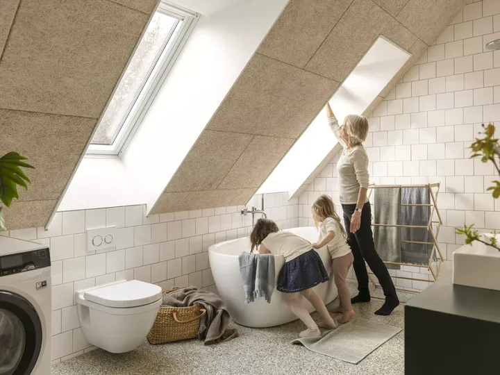 Familie genießt ein helles Badezimmer im Dachboden mit VELUX Dachflächenfenstern und moderner Ausstattung.