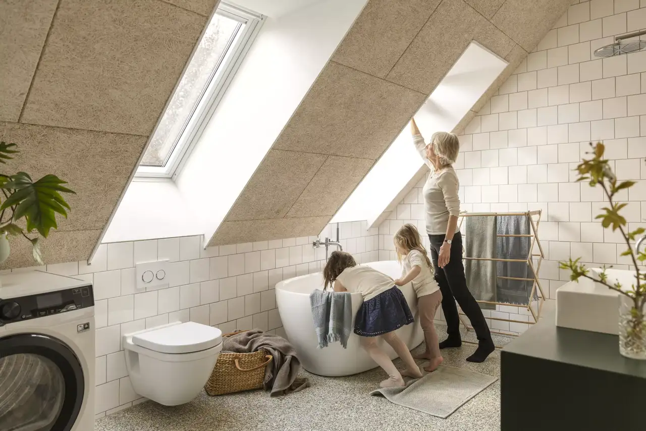 Oma und Enkel im modernen, lichtdurchfluteten Bad mit Toilette unter der Dachschräge | VELUX Magazin