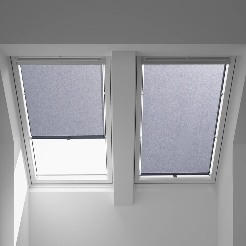 Attic with VELUX roof windows, blinds partially covering, natural light entering.