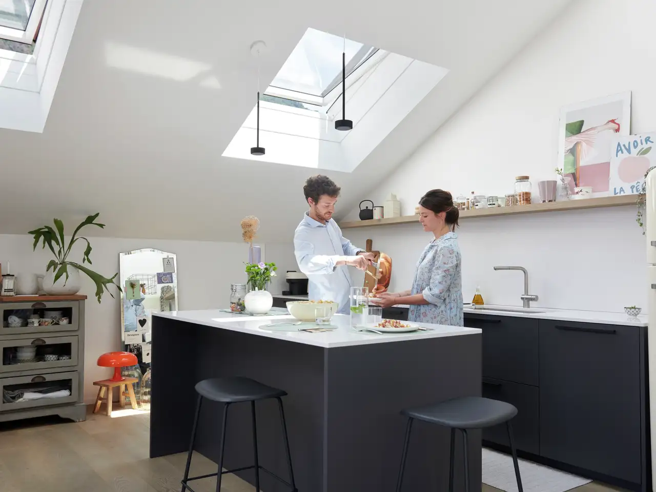 Paar kocht an Kücheninsel in lichtdurchfluteter Küche | VELUX Magazin