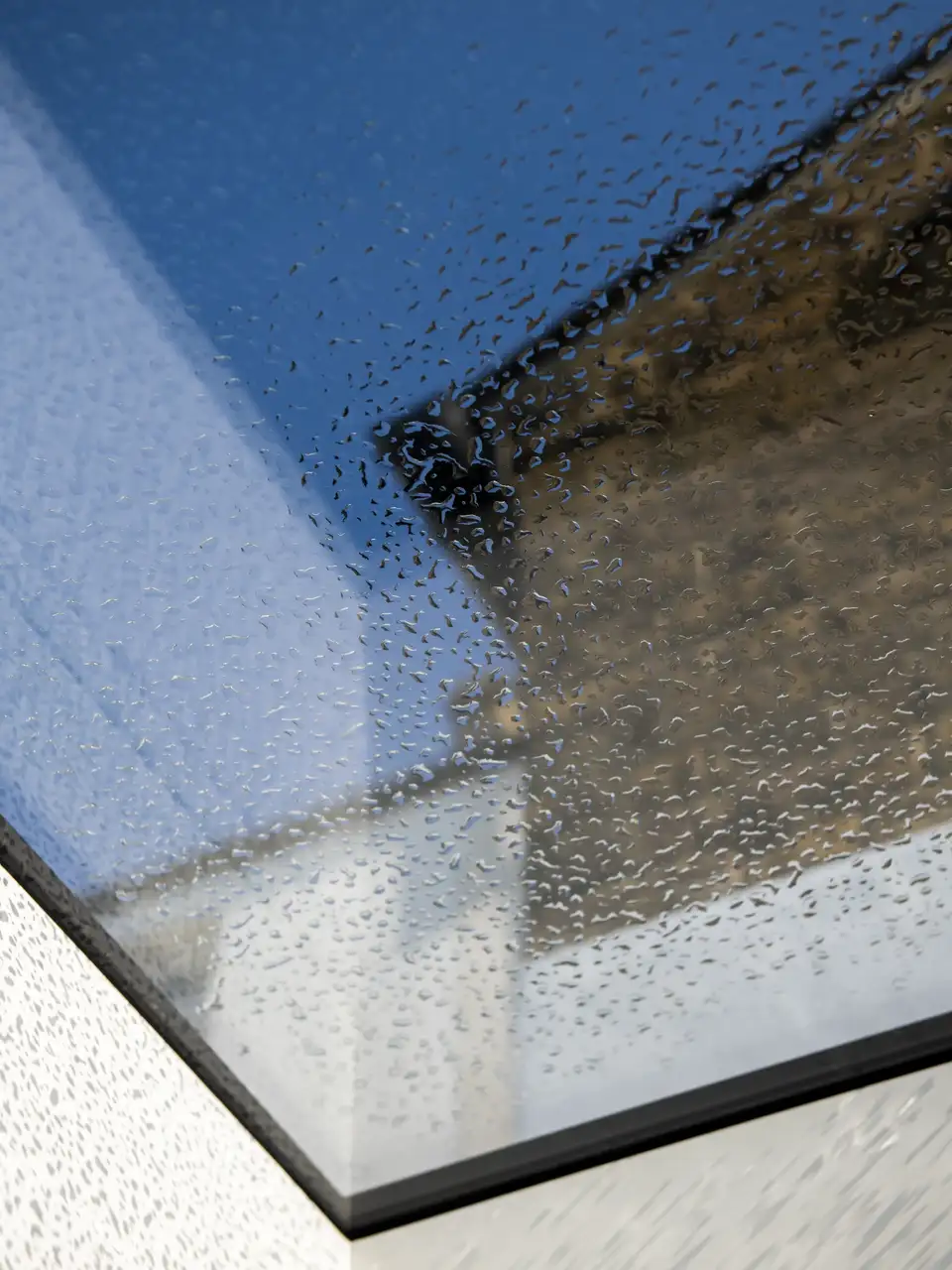 Ventana de tejado VELUX con gotas de lluvia en el exterior