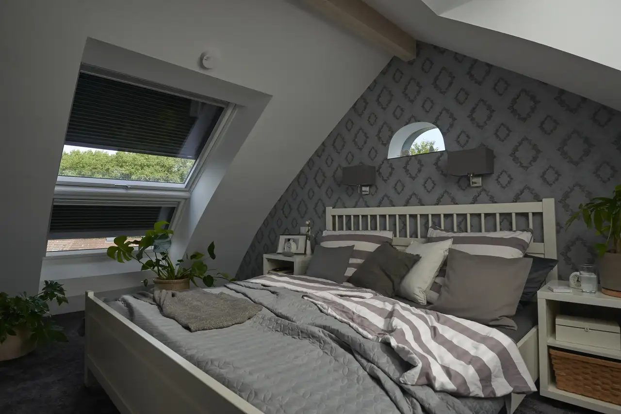 Zolderkamer met VELUX dakvensters die worden beschermd door rolluiken.
