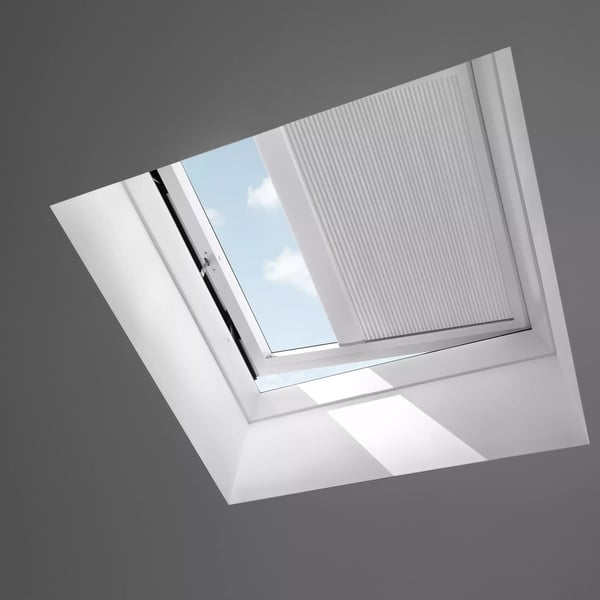 Open VELUX roof window on a sloped ceiling, sky view visible.