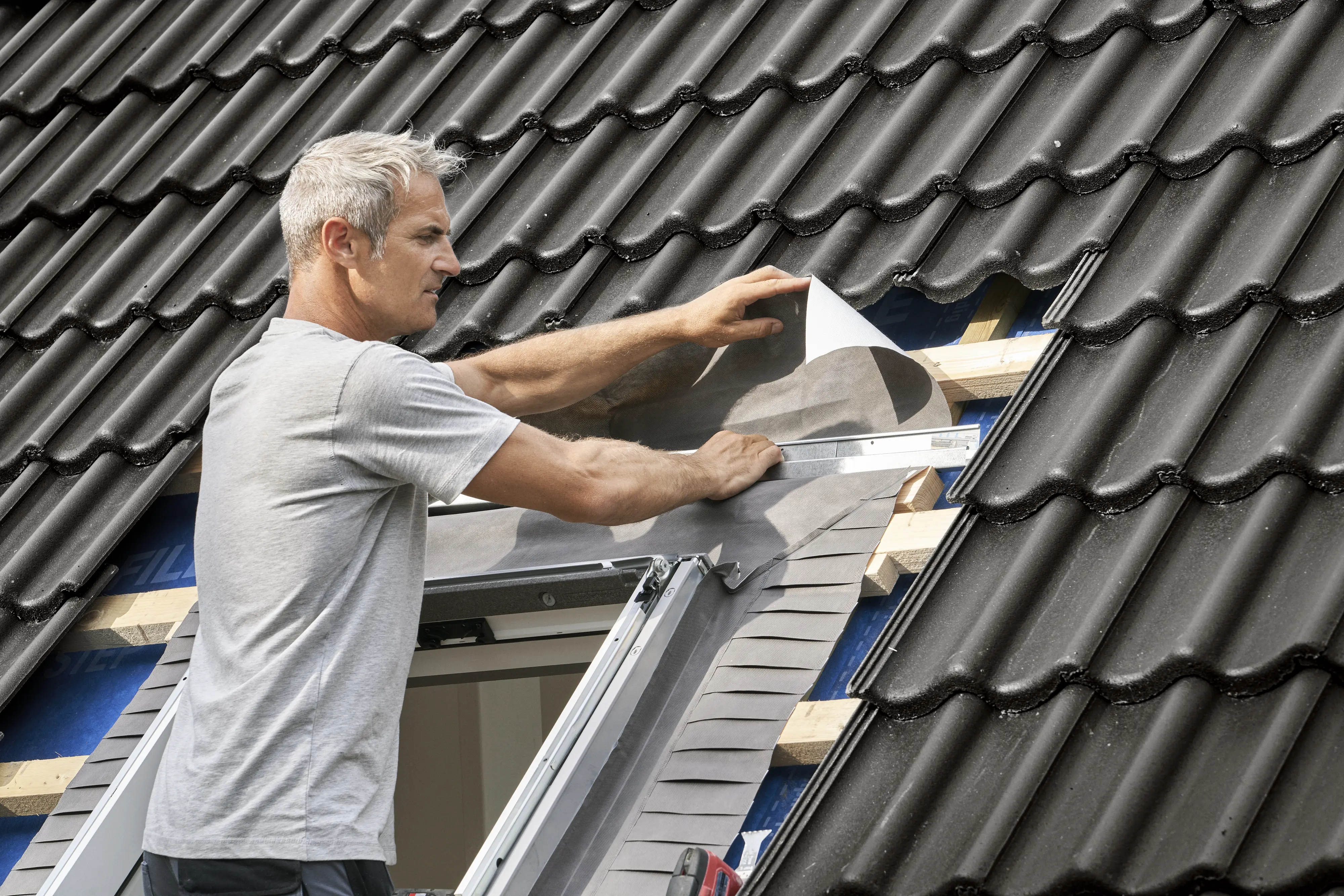 Встановлення мансардного вікна VELUX на черепичний дах професіоналом.