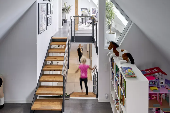 Zwei Kinder rennen Treppe aus dem Dachgeschoss herunter | VELUX Magazin