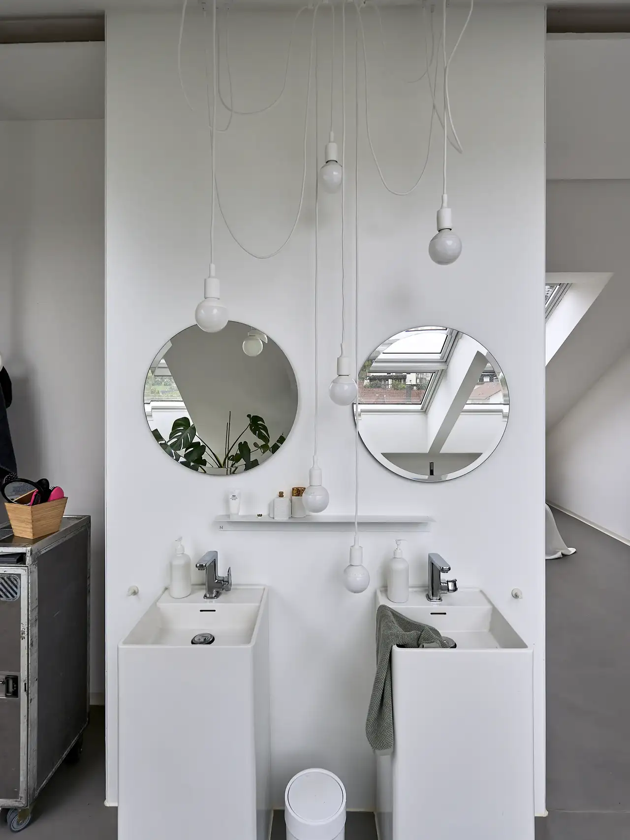 Due lavabi stretti con rubinetti d'argento, ciascuno con due specchi rotondi e una lampada a incandescenza | Rivista VELUX