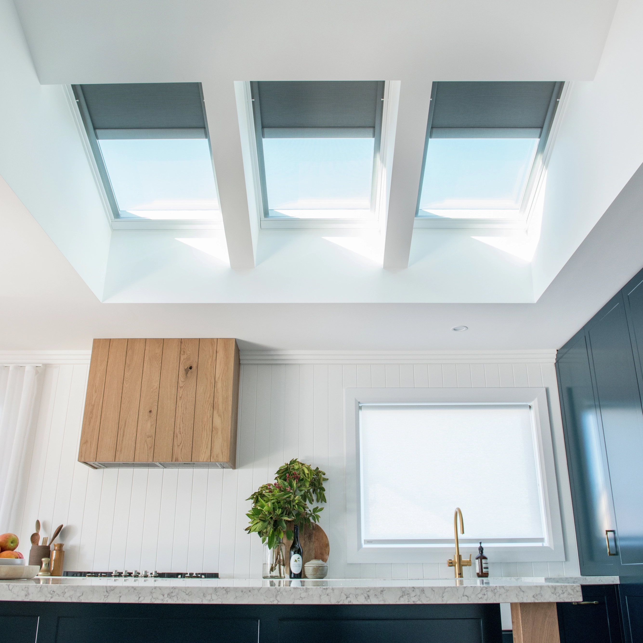 Modern kitchen with VELUX roof windows and dark blue cabinets.