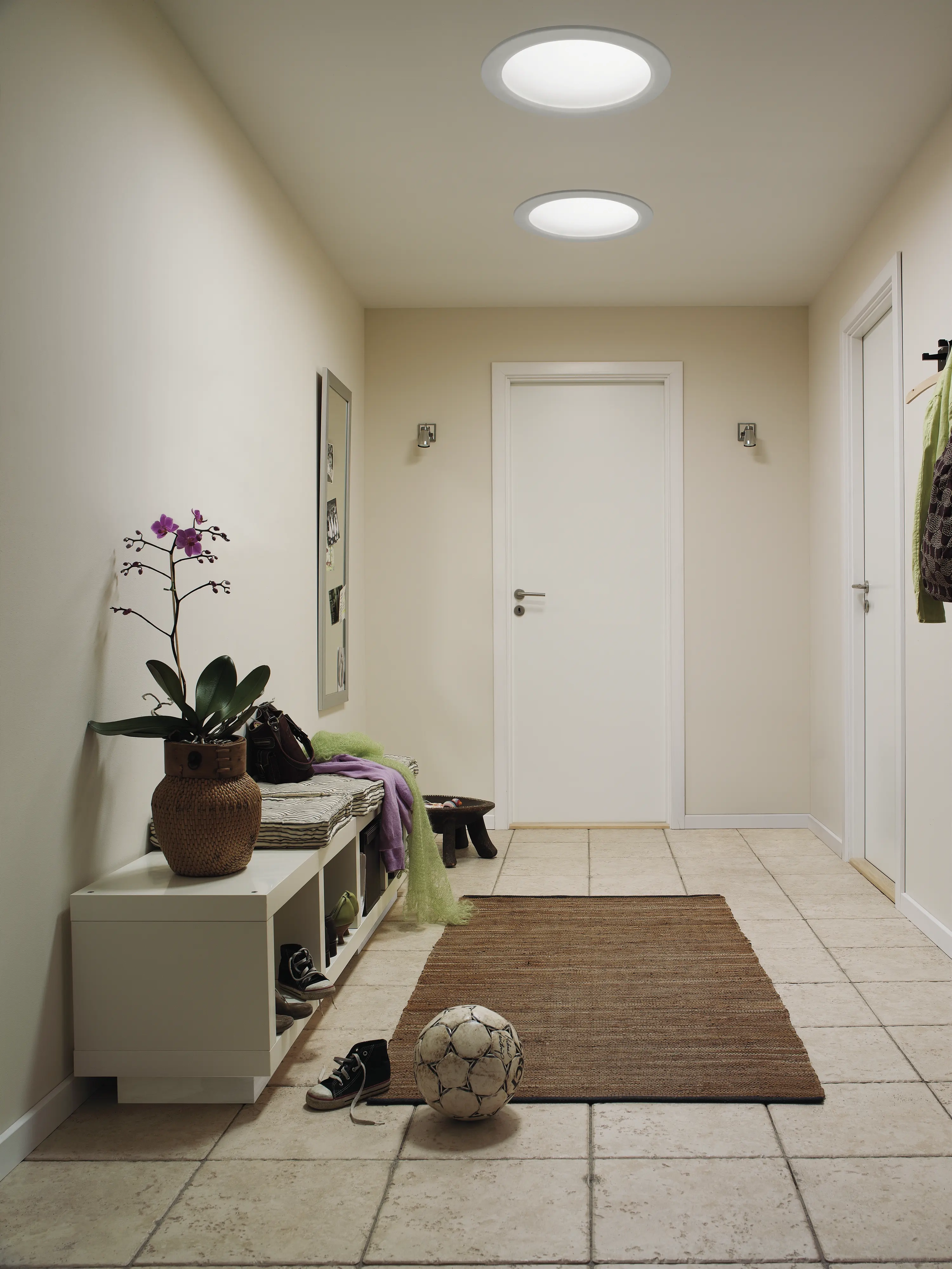 Hallway with VELUX roof windows, bench, and decor.