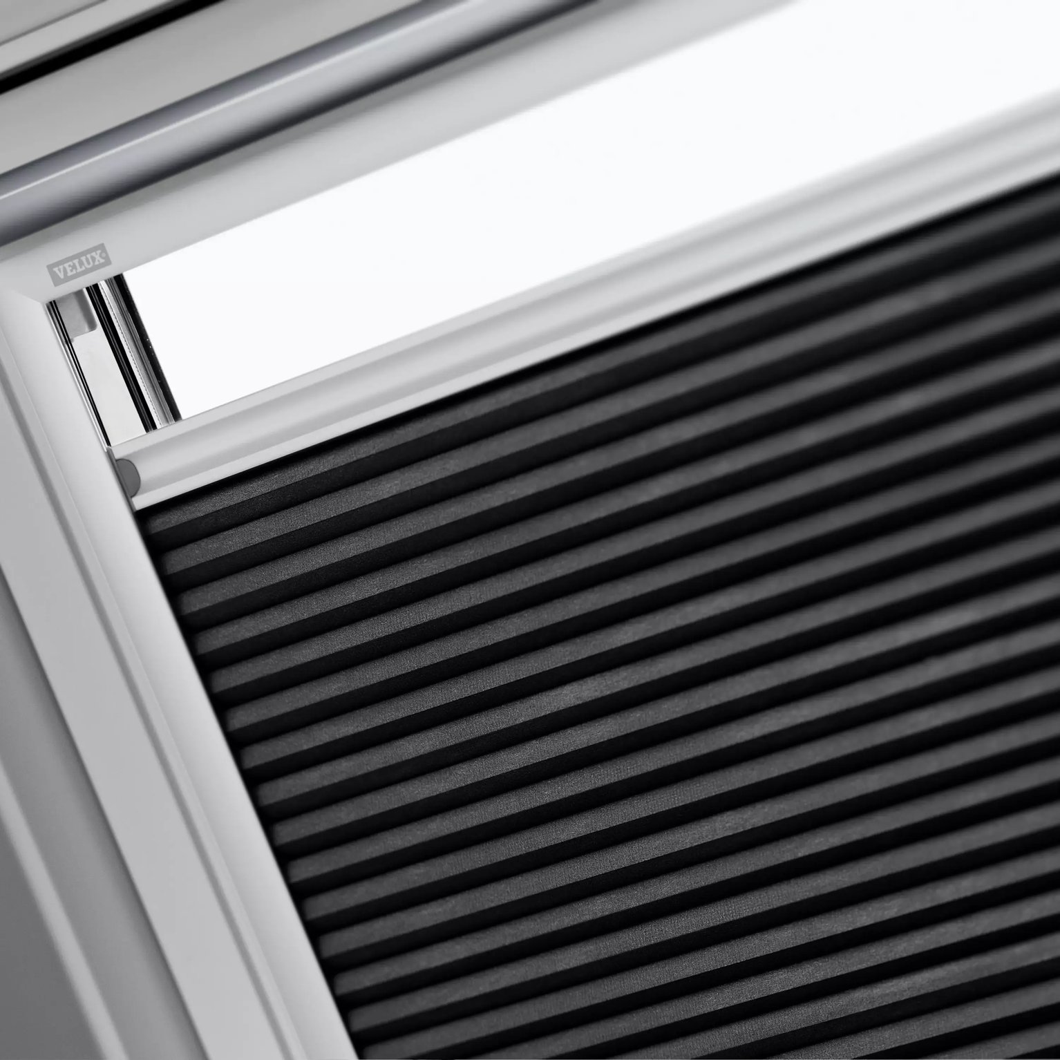 Close-up of VELUX roof window with partially open blind.