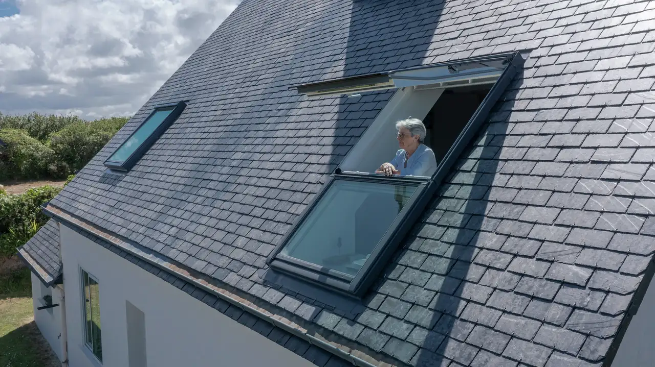Donna anziana affacciata ad una finestra balcone VELUXe in Brittany - replacement, bedroom, Porspoder