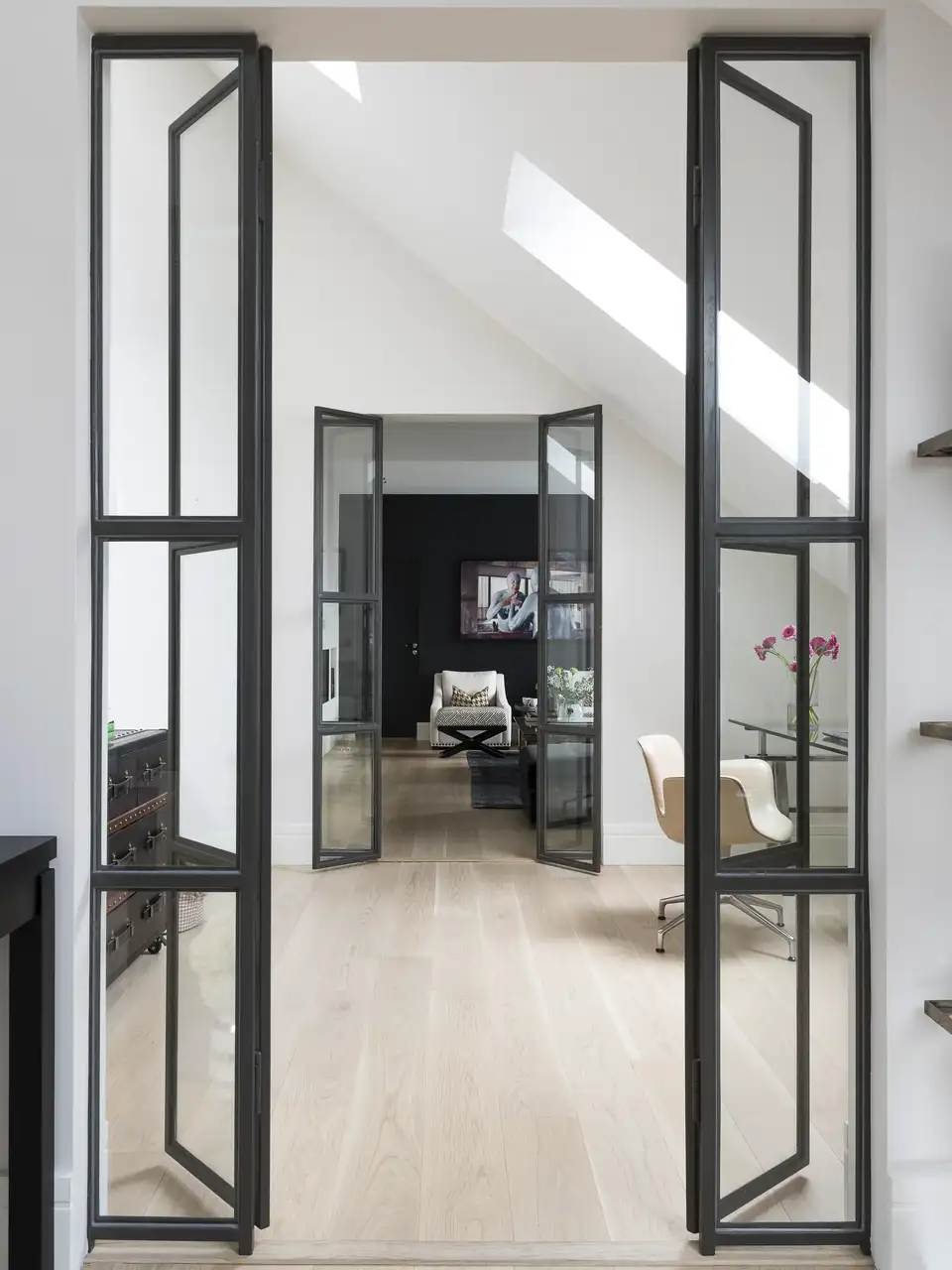 Porte interne vetrate che fanno passare la luce in ingresso da una finestra per tetti VELUX