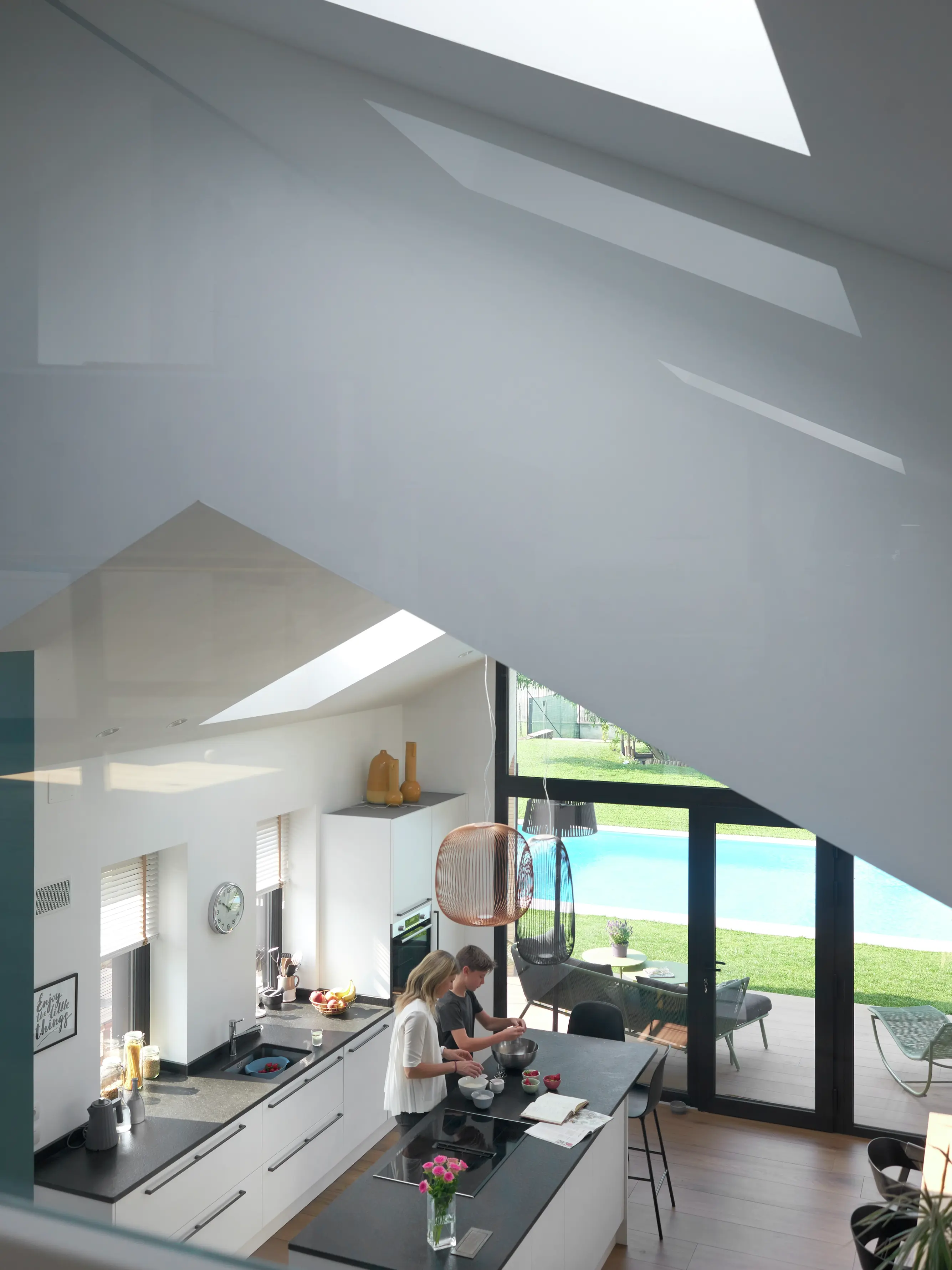 Cucina contemporanea con finestra per tetti VELUX e mobili blu scuro.