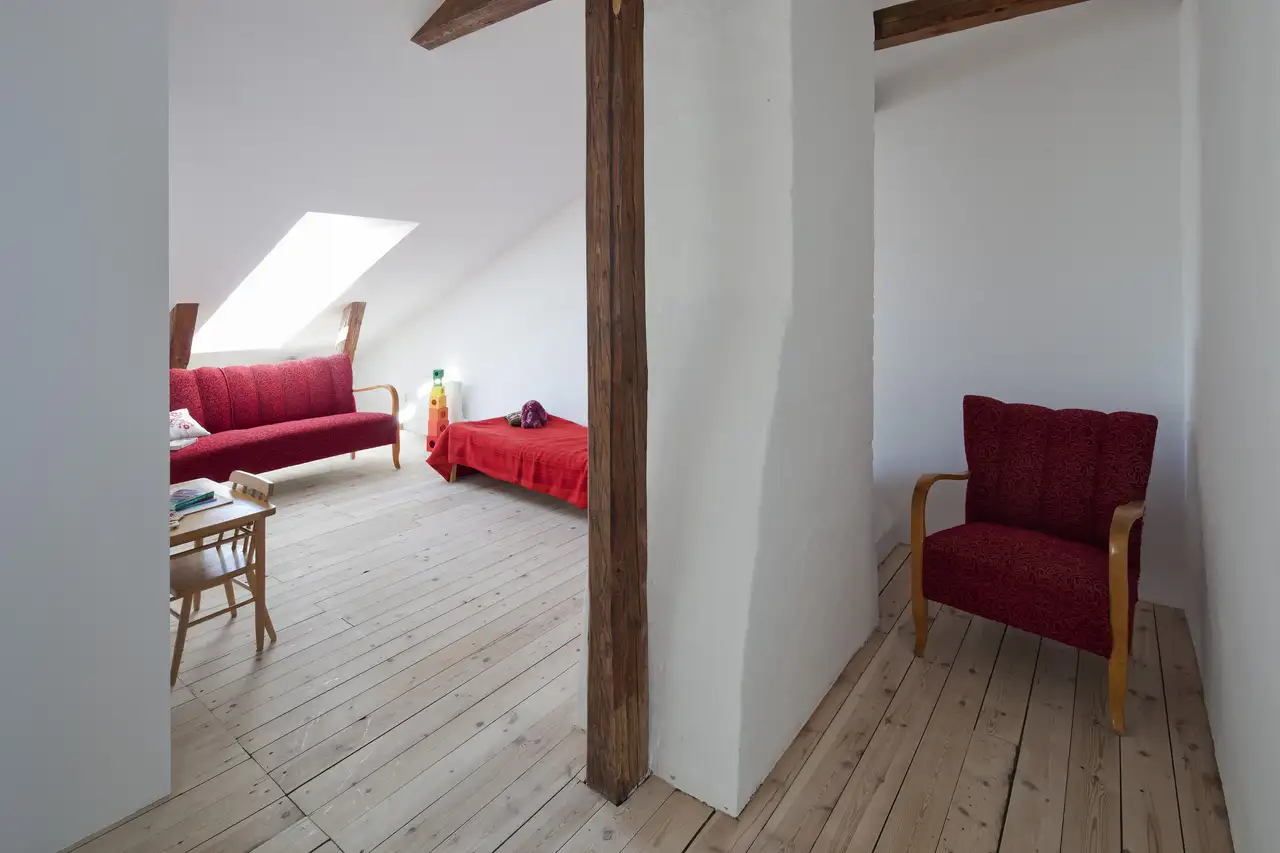 Dachstudio mit Holzboden und roten Sitzgelegenheiten | VELUX Magazin