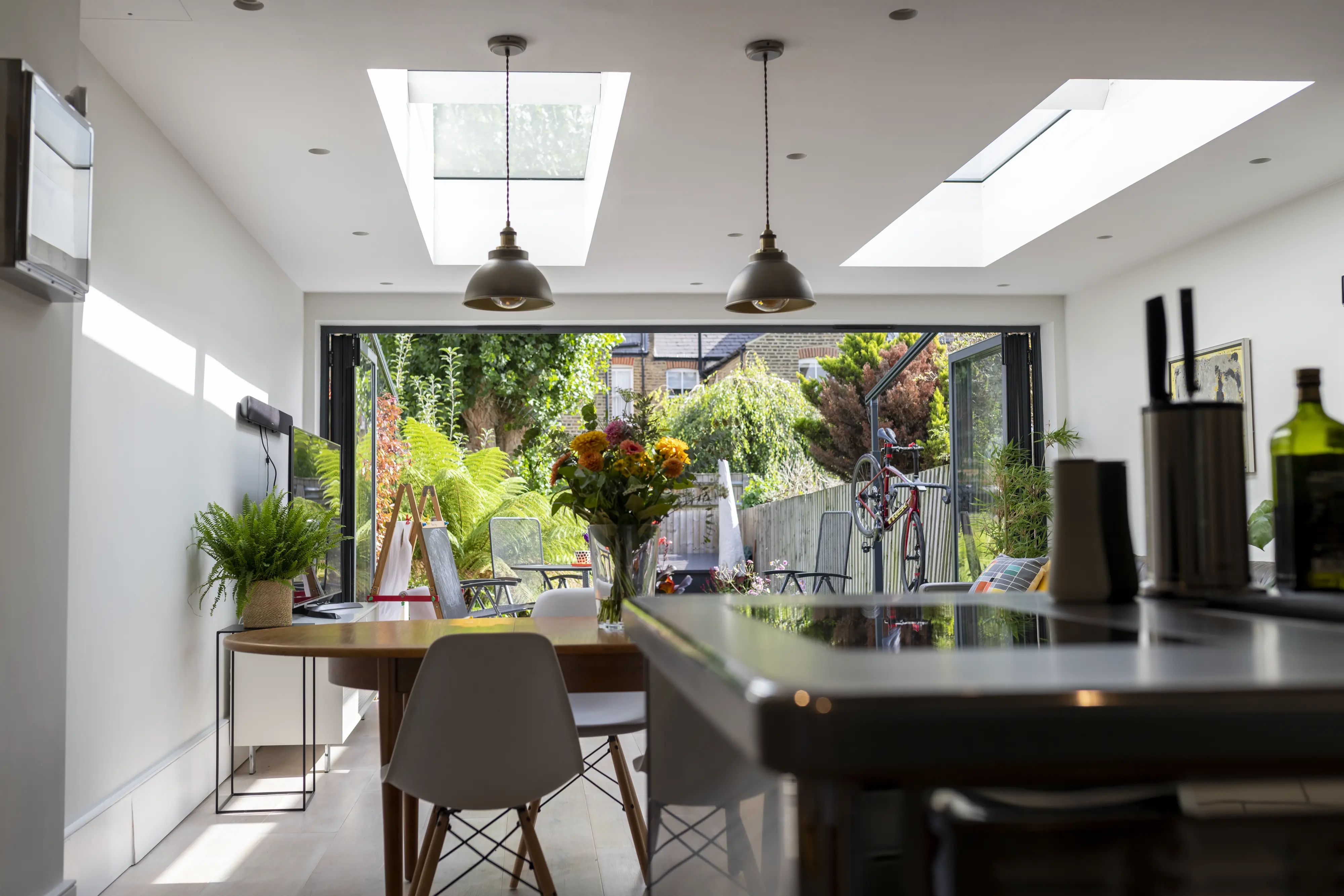 Dining room with VELUX roof windows, modern furniture, and garden view.