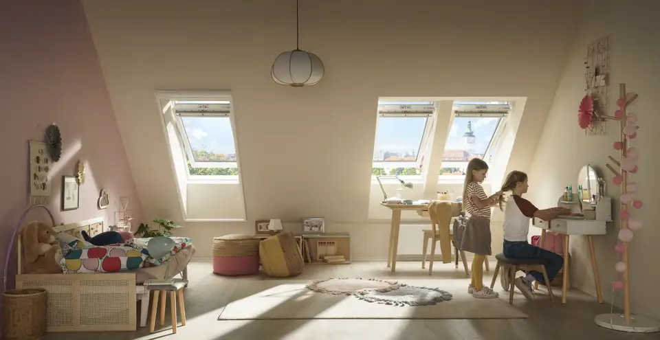 Due bambine nella loro cameretta illuminata da tre finestre per tetti