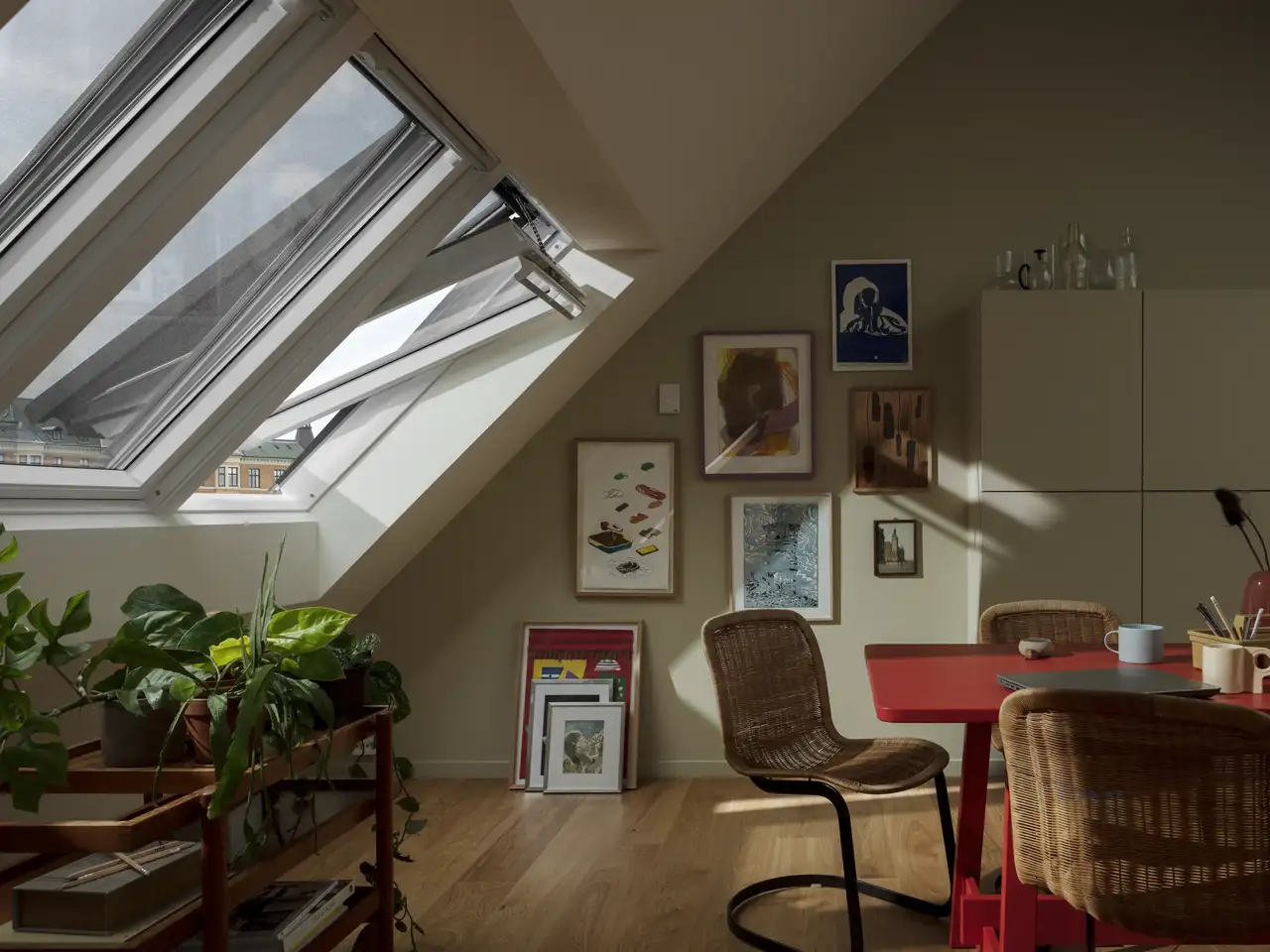 Accogliente sala da pranzo sotto un tetto spiovente con lucernari aperti e luce naturale | Rivista VELUX