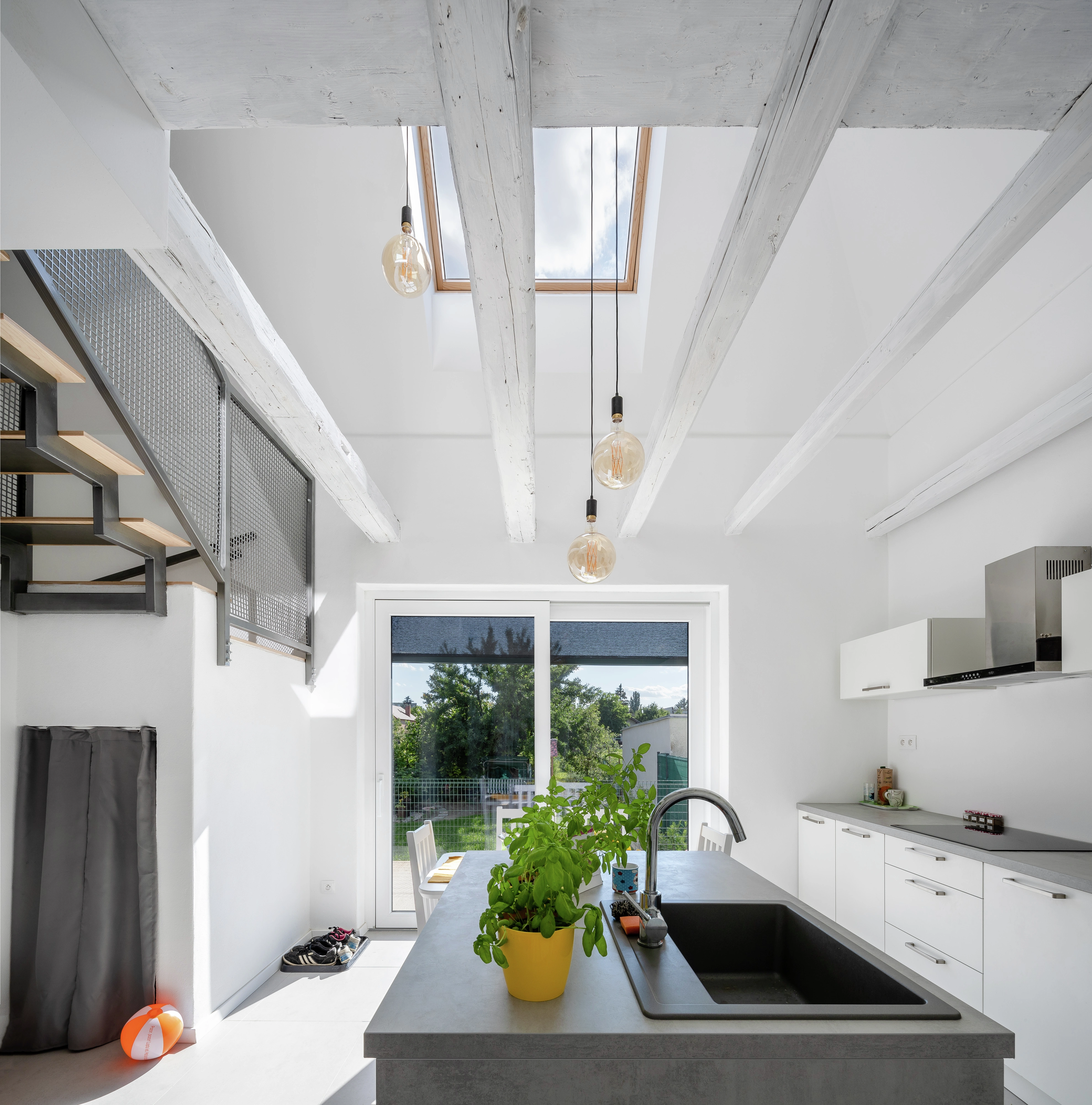 Strešné okno VELUX a priznané trámy nad otvorenou galériou dodávajú kuchyni výnimočnú atmosféru