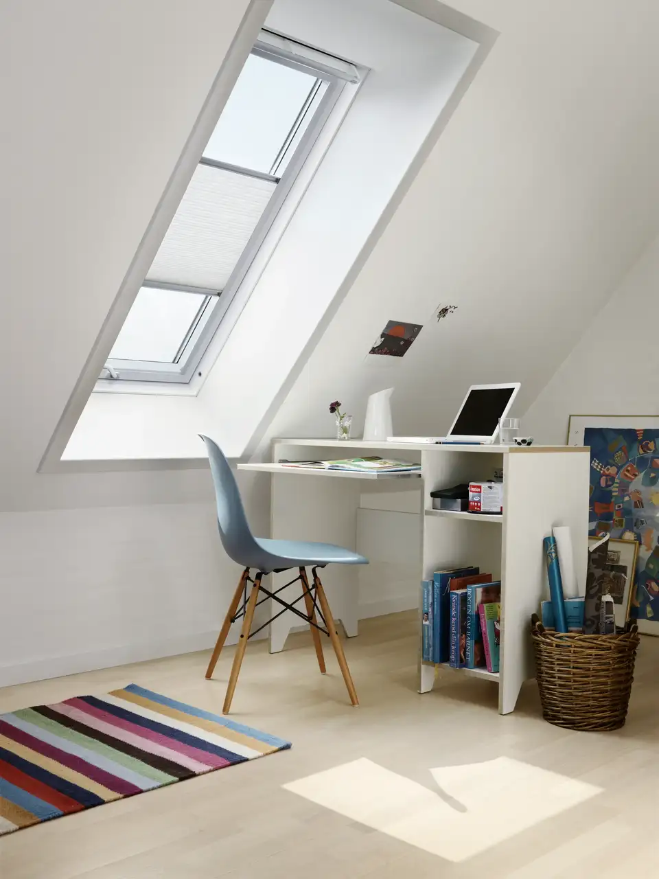 Chambre d’enfant sous les toits avec bureau près d’une fenêtre de toit