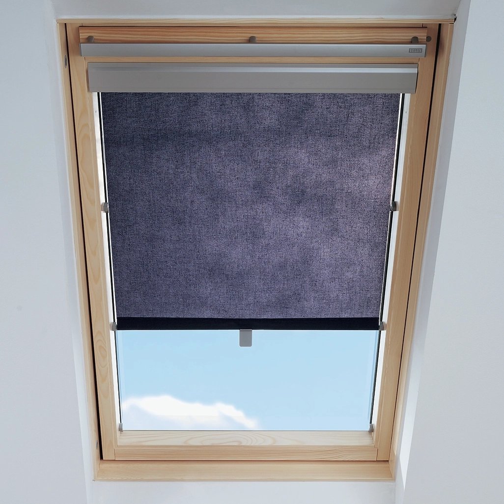 VELUX roof window with partially drawn blind, blue sky visible.