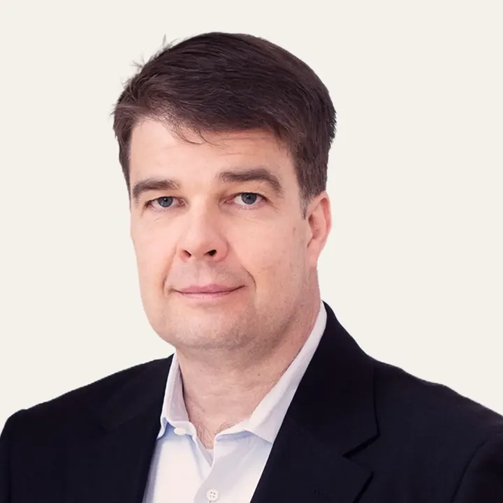 Man in a black suit and white shirt, professional appearance.