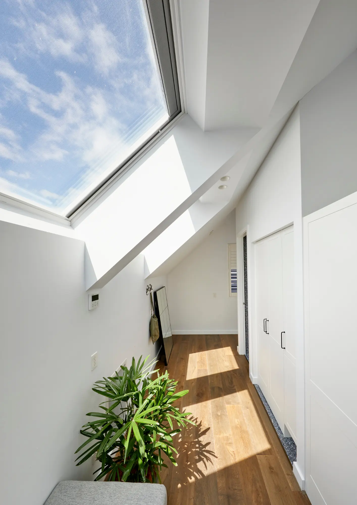 Attic room with sloped ceiling and large roof window.