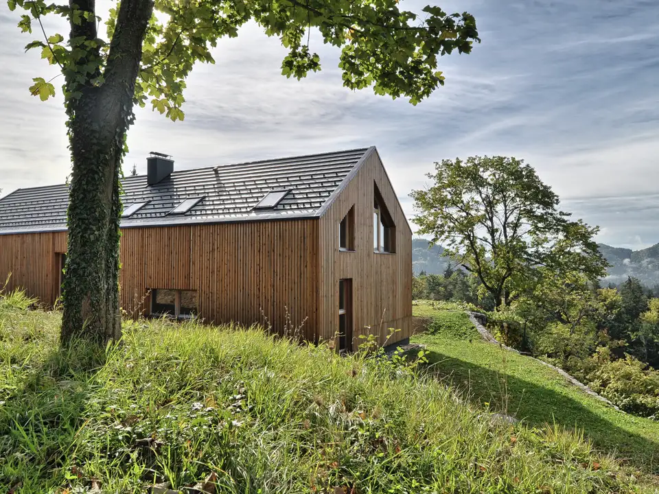  Casa in legno con tetto a falde e finestre  per tetti VELUX, immersa nella natura.