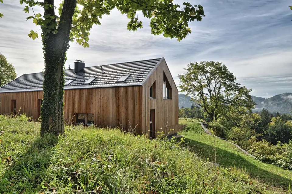 maison en bois avec toit en pente et fenêtres de toit VELUX, en pleine nature