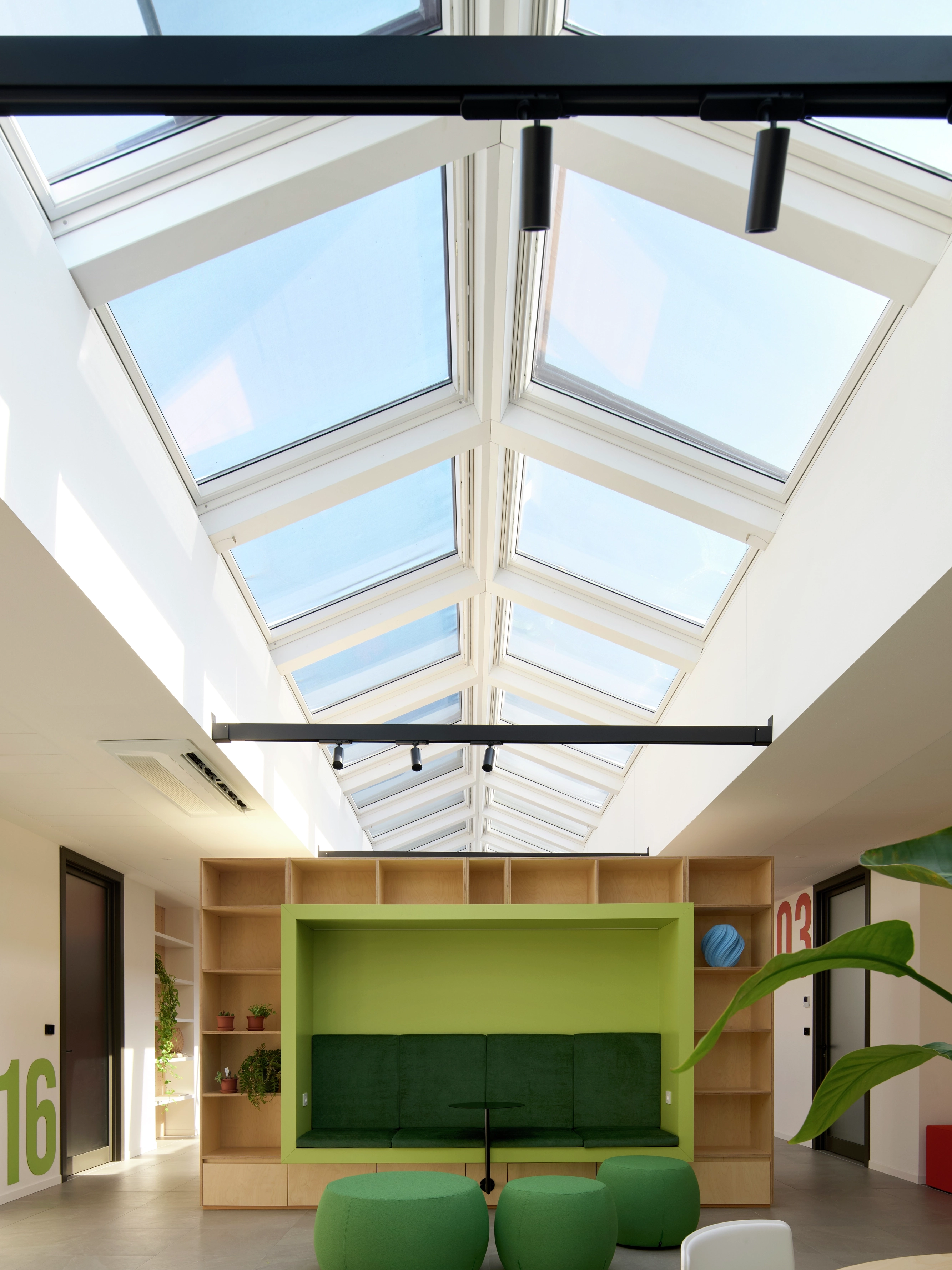 Area conviviale con sedute verdi sotto finestre per tetti VELUX.