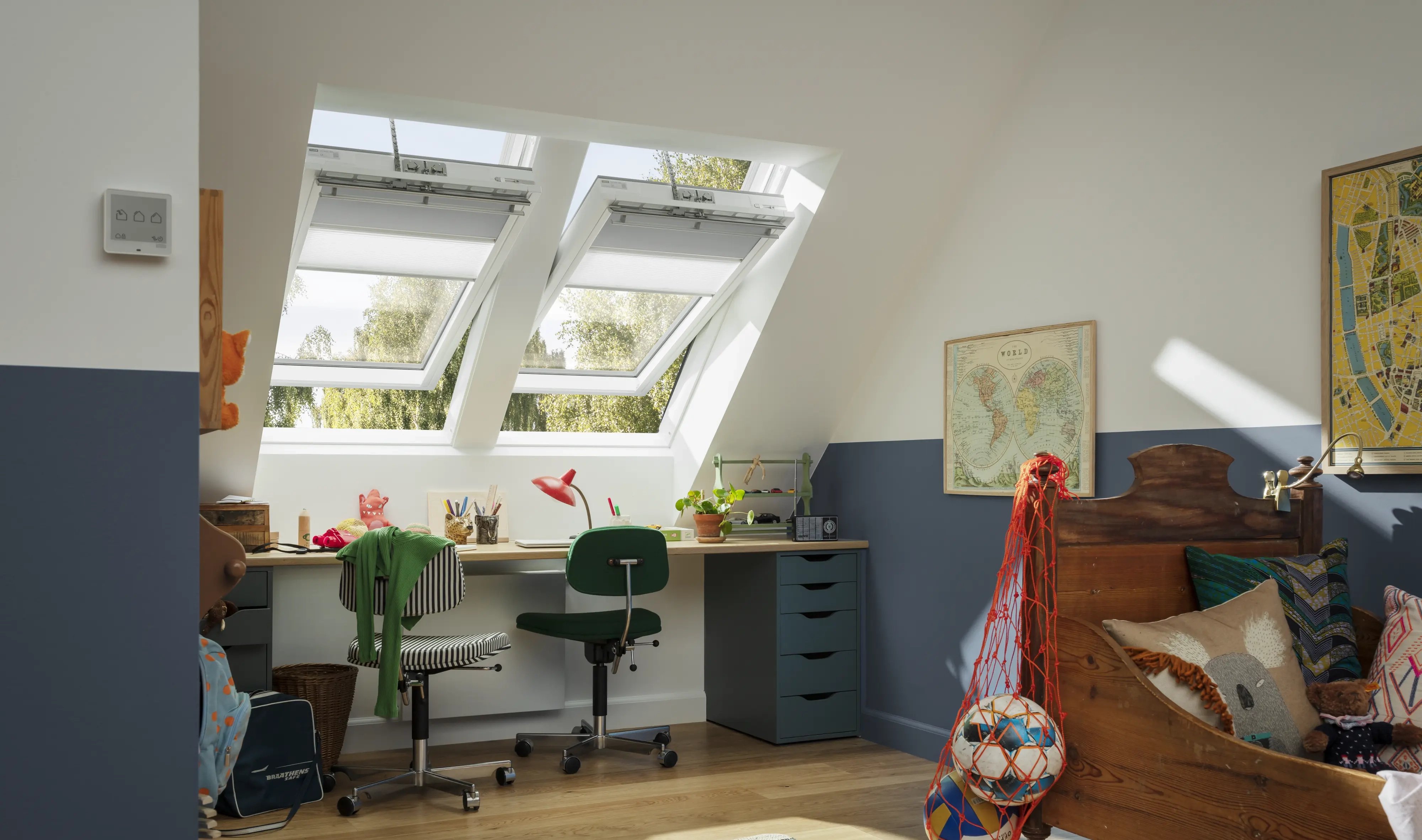 Attic teenage room with sloped ceiling and open VELUX roof windows.