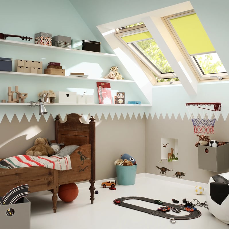 Kids room with sloped ceiling and VELUX roof windows, toys and books.