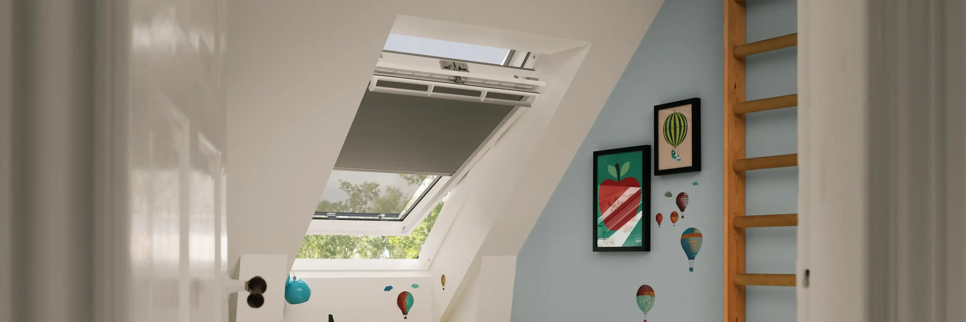 Kids room in attic with sloped ceiling and VELUX roof window, colorful decor.