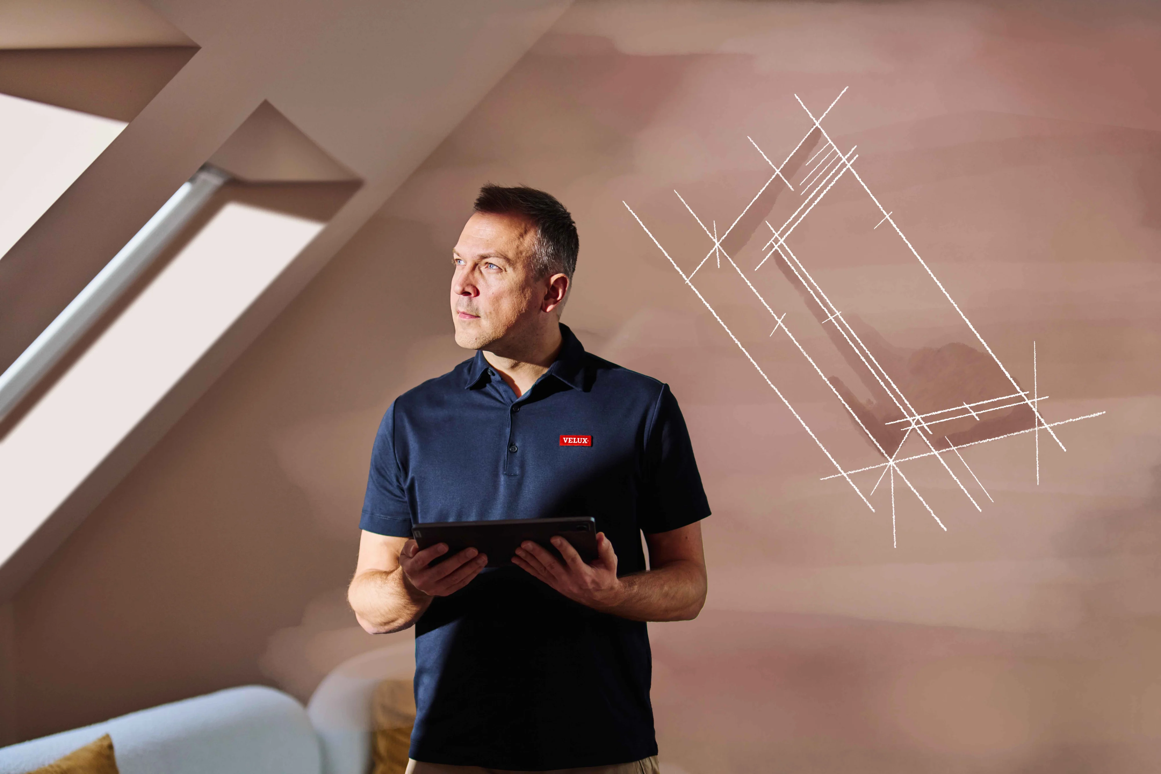 Mężczyzna trzymający tablet i patrzący w bok.