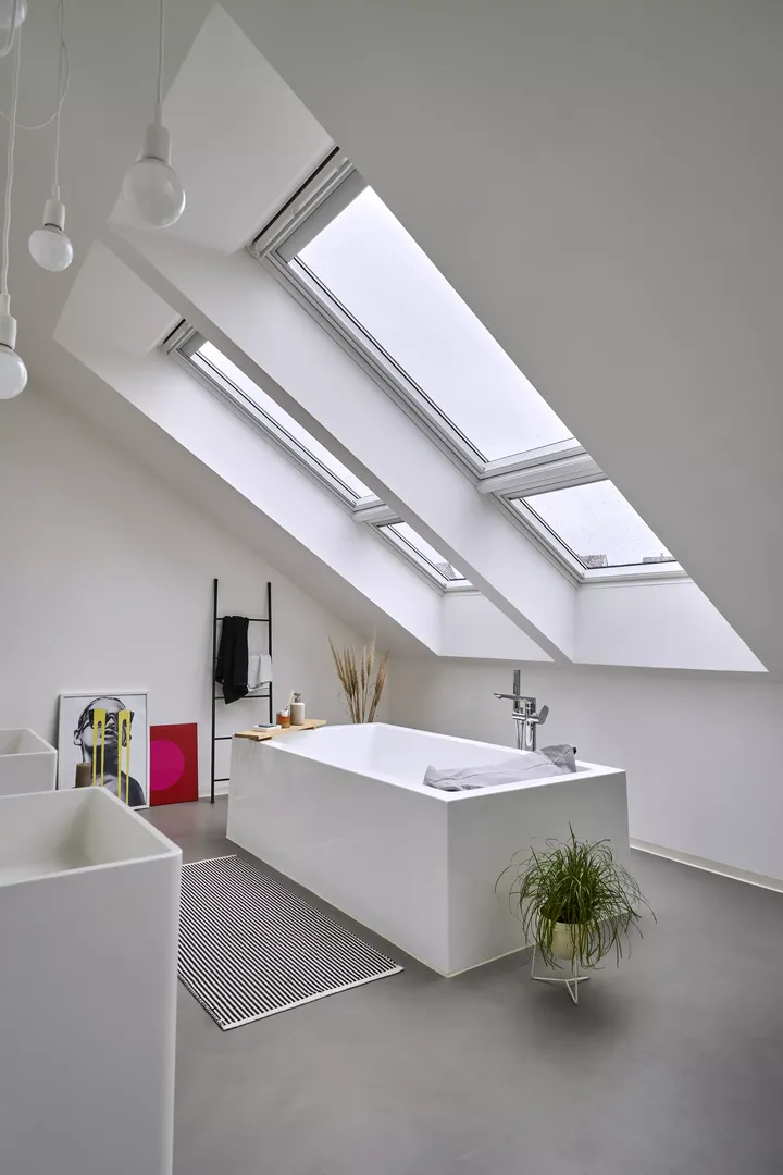 Modernes Badezimmer mit freistehender Badewanne und VELUX Dachflächenfenstern, die für natürliches Licht sorgen.