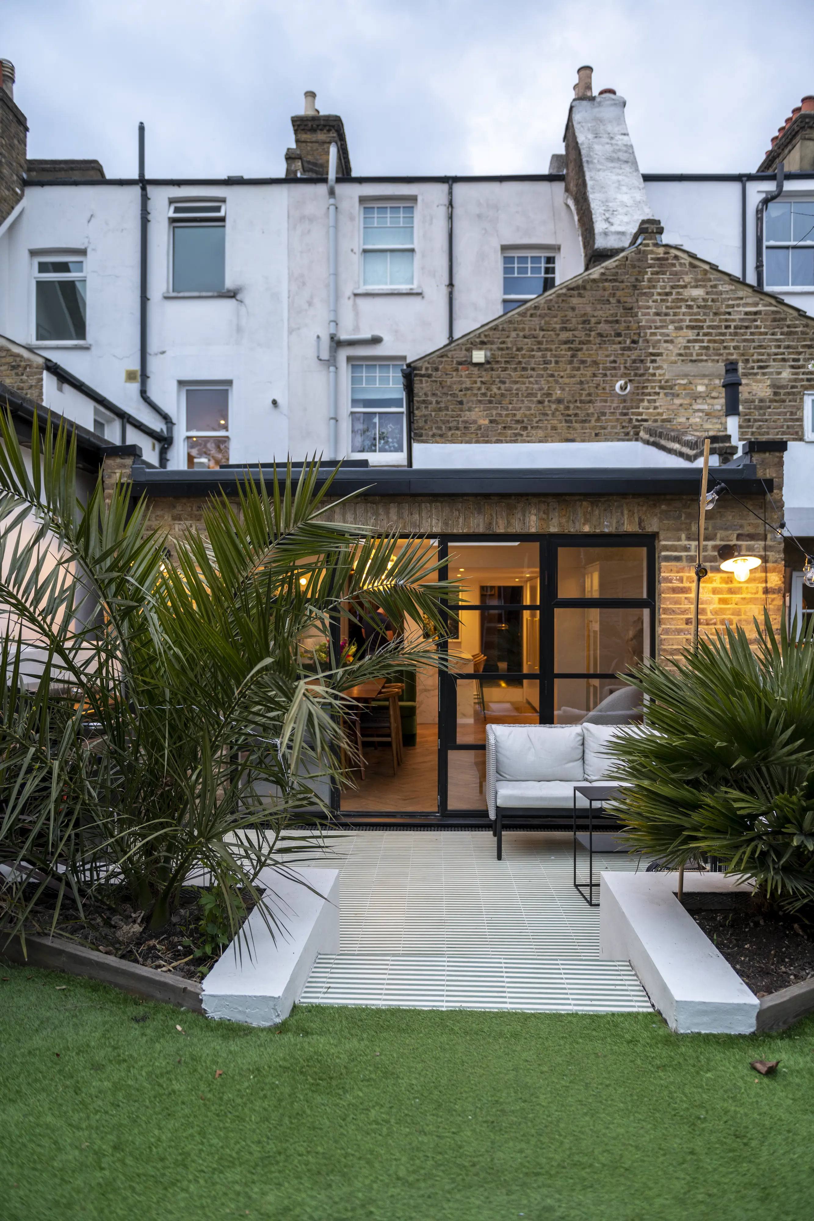 Terraced house extension with glass doors and garden view.