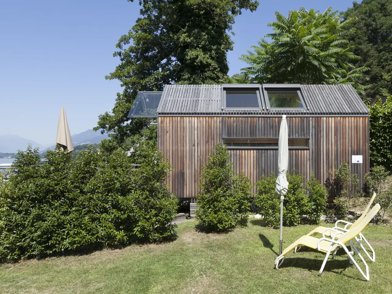 Kleines Ferienhaus aus Holz mit Sonnenliegen direkt am See | VELUX Magazin