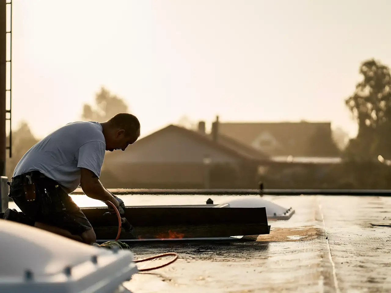 Handwerker auf Flachdach wartet Dachfenster |  VELUX Magazin