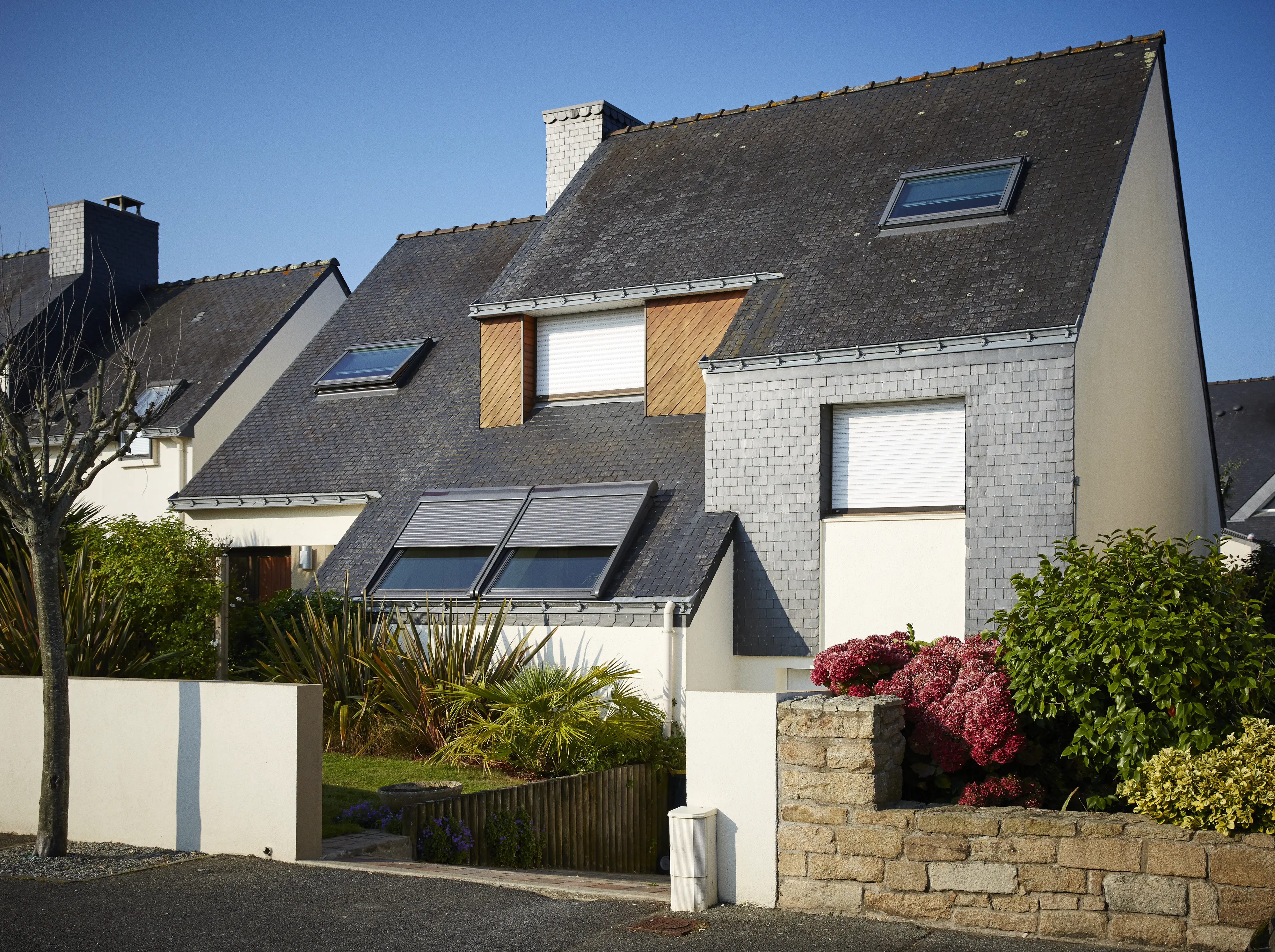 Modern terraced house with slate roof and VELUX roof windows.
