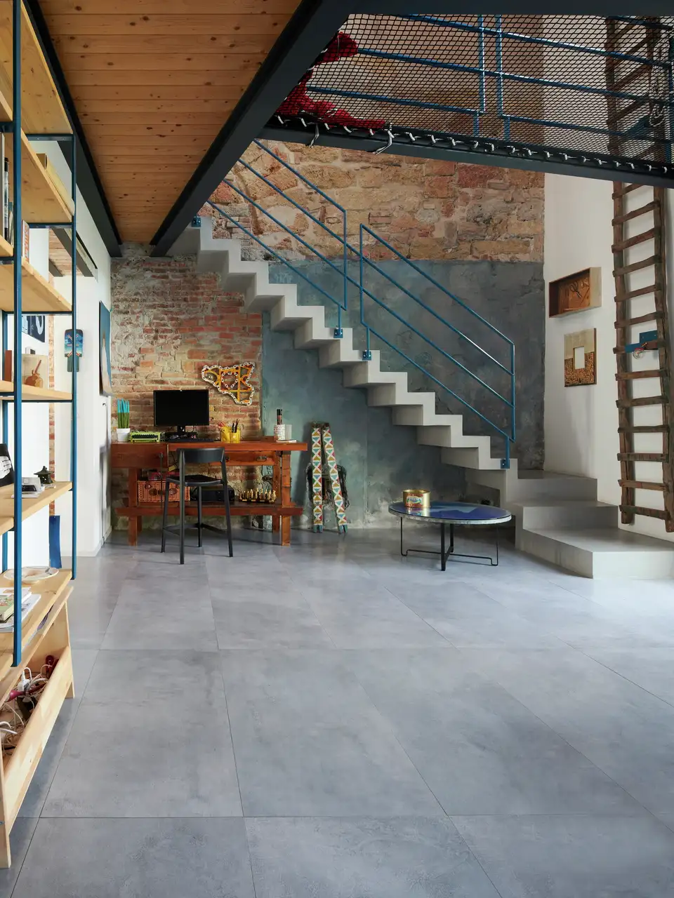 Modern loft with exposed brick walls, staircase and workspace. 