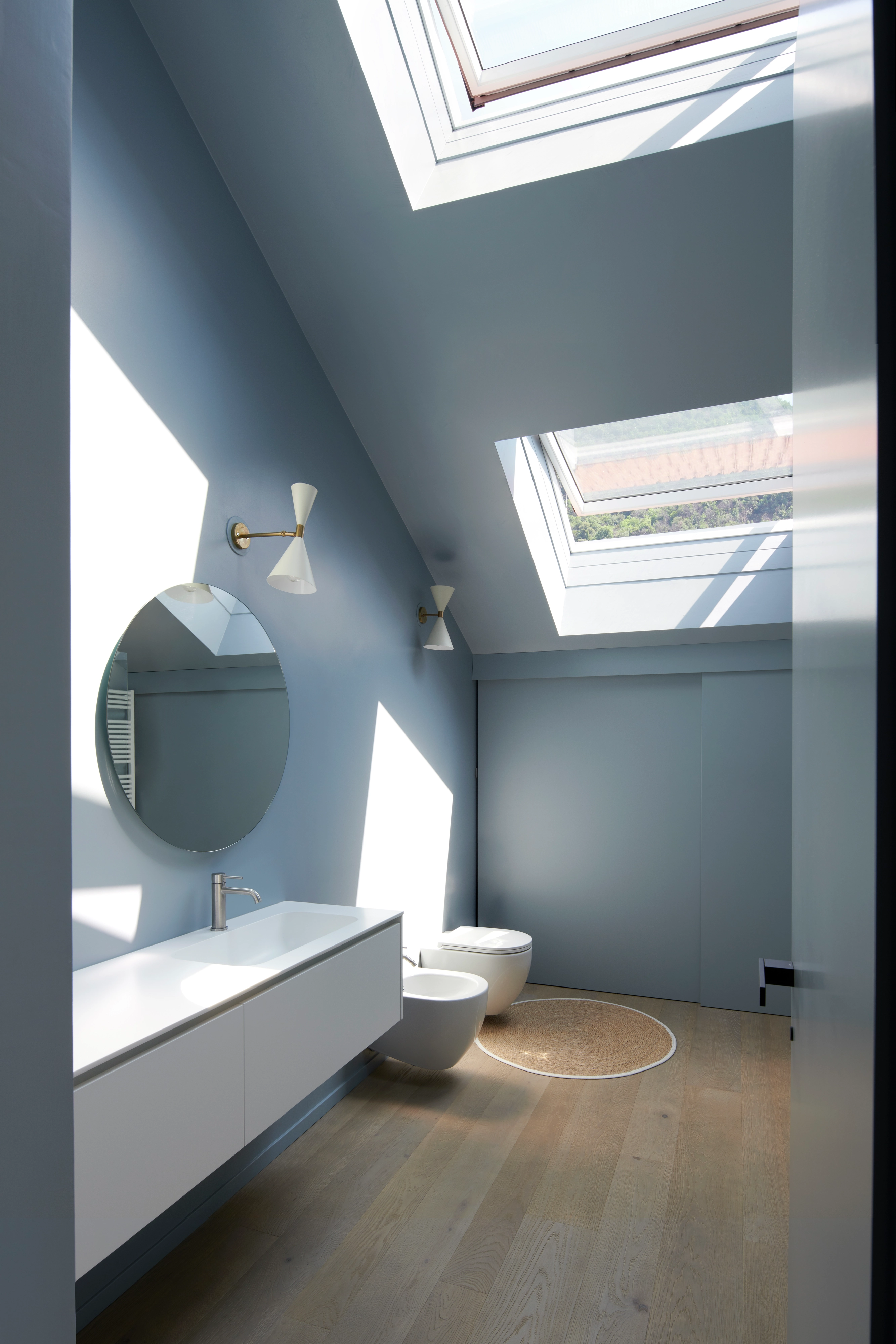 Kupatilo sa kosim plafonom i VELUX krovnim prozorima, prodor prirodnog svetla.
